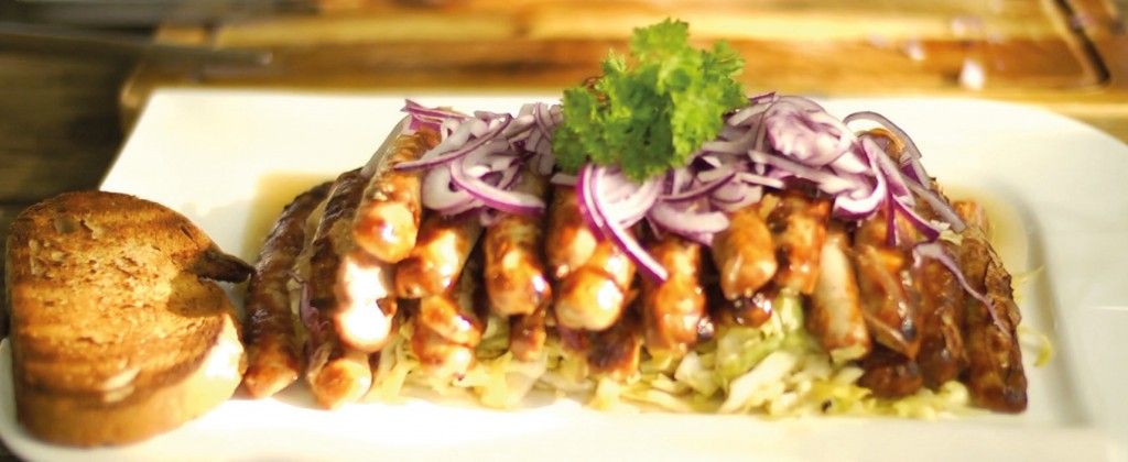 Schneider Weisse Marinierte Bratwürste auf Spitzkohl fertig serviert mit einem Stückchen Brot als Beilage