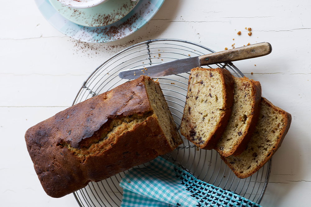 Schokoladen Nuss Kuchen in Kastenform mit Kaffeetasse daneben